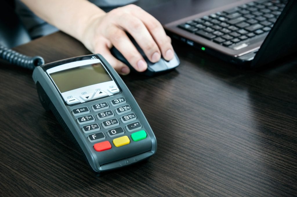 Payment terminal in the office. Laptop in the background